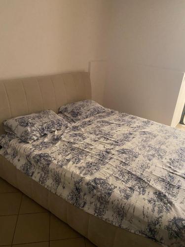een bed met een blauwe en witte deken erop bij Globe apartement in Tirana