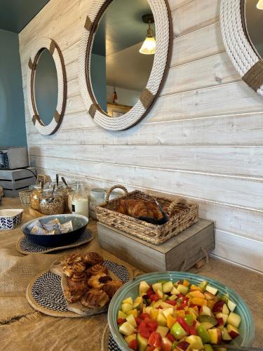 a table with a bowl of fruit and a basket of bread at Beach House Hotel in Seahouses