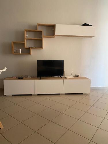 een woonkamer met een flatscreen-tv op een kast bij Globe apartement in Tirana