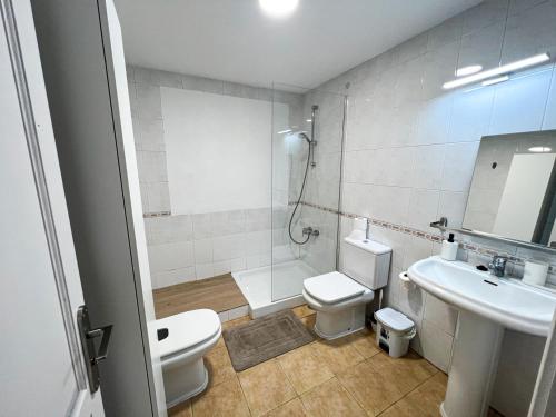a bathroom with a toilet and a sink and a shower at La Milagrosa Surf House & CoWork in Lajares