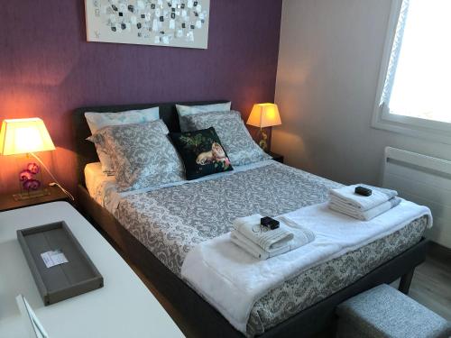 Chez Annie في دويه-لا-فونتين: غرفة نوم عليها سرير وفوط