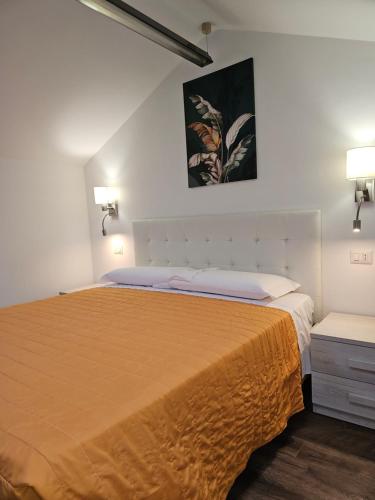 a bedroom with a large bed with a yellow bedspread at Victoria Royal Garden in Como