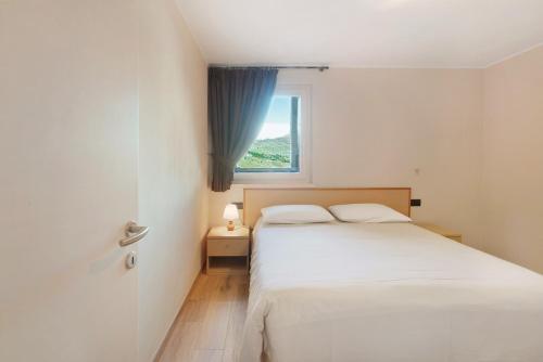 a bedroom with a white bed and a window at Al Baitin Trepalle in Livigno