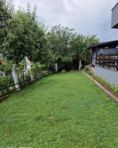a yard with a fence and green grass at Apartman PanoramaTz in Tuzla