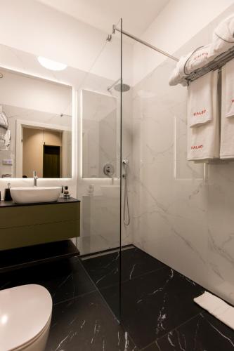 a bathroom with a shower and a toilet and a sink at Kaleo apartments - Hanza Tower in Szczecin