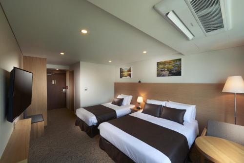 Postel nebo postele na pokoji v ubytování Benikea Jungmun Hotel