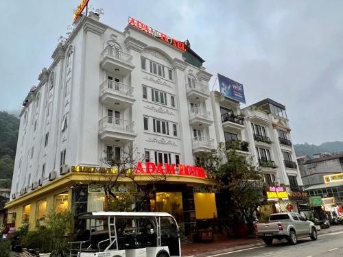 a white building with a sign on top of it at Sapa Adam Hotel in Lao Cai