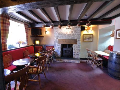 un restaurante con mesas y sillas y una chimenea en Ye Olde Cheshire Cheese Inn, en Castleton