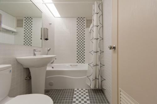 基隆的住宿－華帥海景飯店，白色的浴室设有水槽和卫生间。