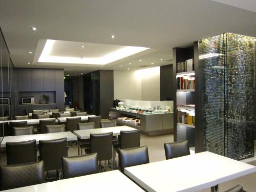 a restaurant with tables and chairs and a library at Harbor View Hotel in Keelung