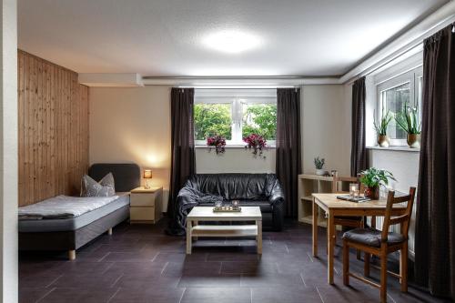 - un salon avec un canapé et une table dans l'établissement Pension Haus am Kohfurth, à Norderstedt