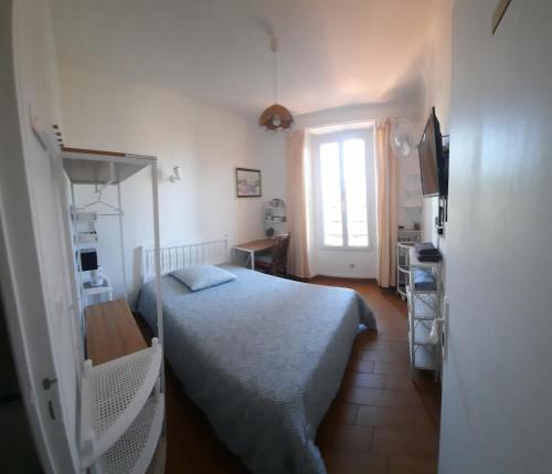une petite chambre avec un lit et une fenêtre dans l'établissement GHIS Lotus, à Cannes
