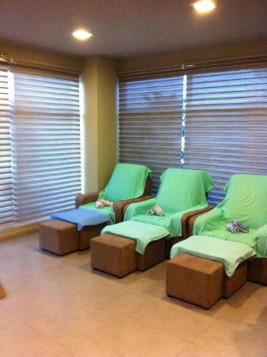a hospital waiting room with green chairs and windows at The Pavilion Hotel in Sandakan