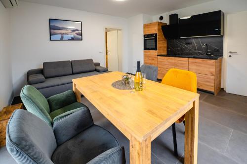 sala de estar con mesa de madera y sillas en Apartments Luxury AD, en Jesenice