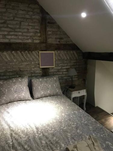 um quarto com uma cama e uma parede de tijolos em Petite maison Liégeoise «la cabane de Liège» em Liège