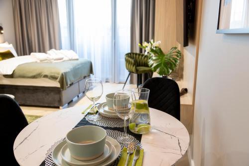 a dining room table with plates and wine glasses at Kaleo apartments - Hanza Tower in Szczecin