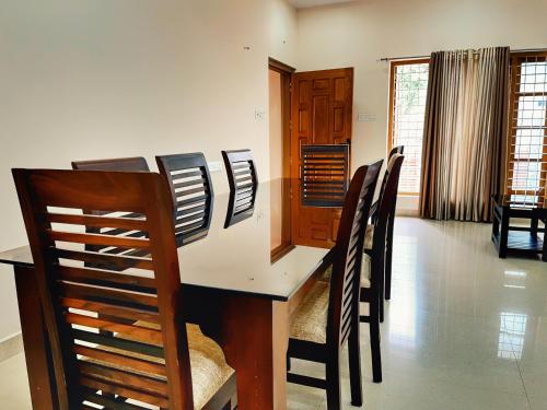uma sala de jantar com mesa e cadeiras em Thrissur Villas Home Stay em Thrissur