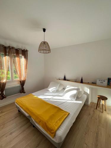 - une chambre avec un grand lit et une couverture jaune dans l'établissement Le bon appart', à Saint-Jean-Pied-de-Port