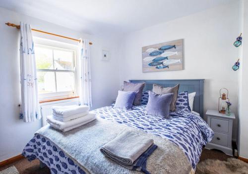 a bedroom with a bed with towels on it at Sea Shanty Cottage in Newlyn