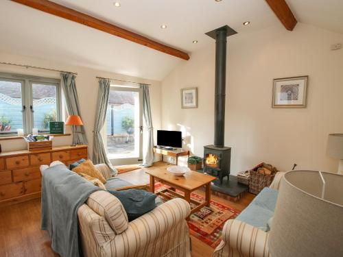 a living room with a couch and a wood stove at Virginia Cottage in Acton Burnell
