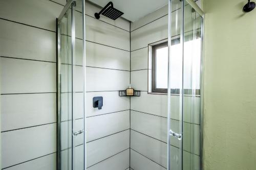 ducha con puerta de cristal y ventana en Self-Catering at Cozy Comfort en Durban