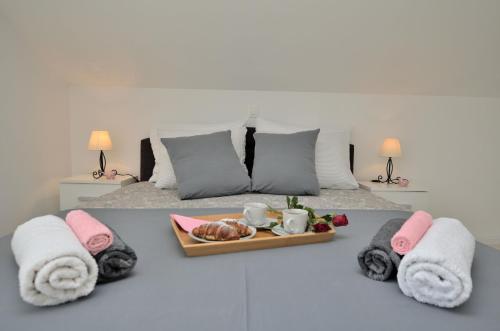 uma cama com toalhas e uma bandeja de comida em Apartments Viktoria em Lovran