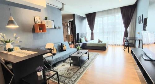 a living room with a blue couch and a desk at Regalia Suites KLCC View Rooftop Infinity Pool by SHI in Kuala Lumpur