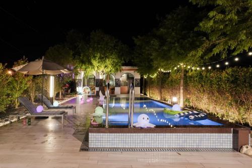 a swimming pool at night with lights in a backyard at Sakura VILLA B&B in Yuanshan