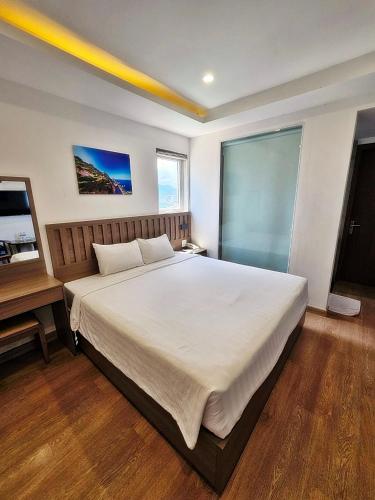 1 dormitorio con 1 cama blanca grande y escritorio en Country House en Quy Nhon