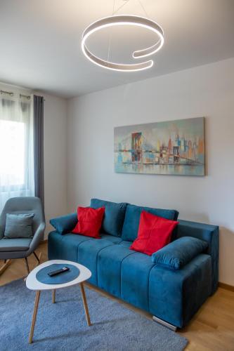 a blue couch with red pillows in a living room at Vila Pekovic Central-Apartman PAMA in Zlatibor