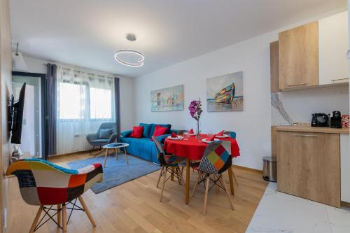 sala de estar con mesa y sofá azul en Vila Pekovic Central-Apartman PAMA, en Zlatibor