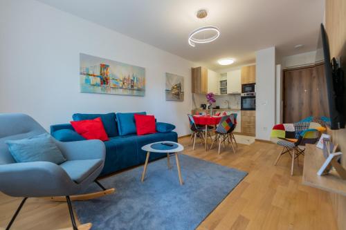 a living room with a blue couch and a table at Vila Pekovic Central-Apartman PAMA in Zlatibor