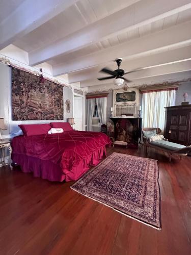 a bedroom with a red bed and a fireplace at Schmit Hotel in Opelousas