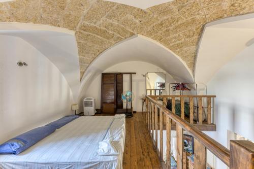 een slaapkamer met een bed in het midden van een kamer bij Antica dimora nel capo di Leuca in Alessano