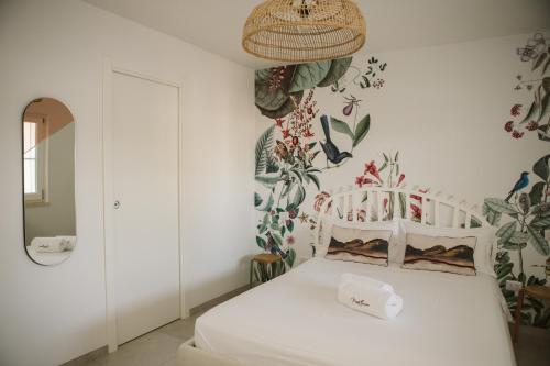 una camera da letto con un letto bianco e carta da parati di Monte Simeone a Polignano a Mare