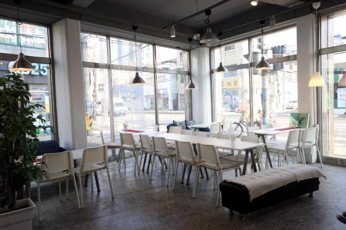 a dining room with tables and chairs and windows at Pohang Youngildae Guesthouse in Pohang