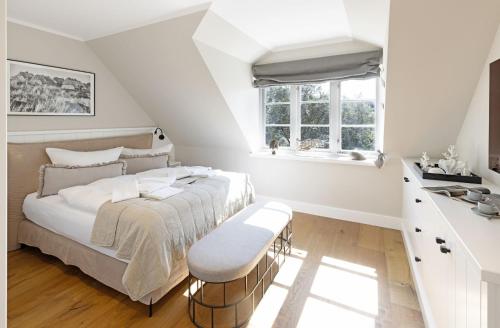 ein weißes Schlafzimmer mit einem Bett und einem Fenster in der Unterkunft Lister Brise in List