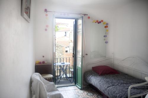 a bedroom with a bed and a door to a balcony at Chez Fred & Aldo Banyuls sur Mer in Banyuls-sur-Mer