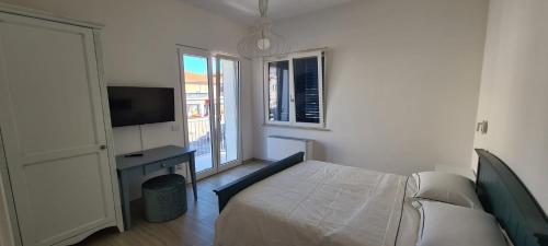 a bedroom with a bed and a tv and a window at ECO-HOUSE DA FRANCO in Civitanova Marche