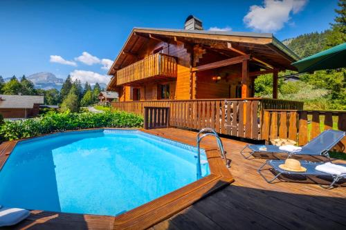 a pool on a deck next to a house at Chalet Igel - OVO Network in Châtel