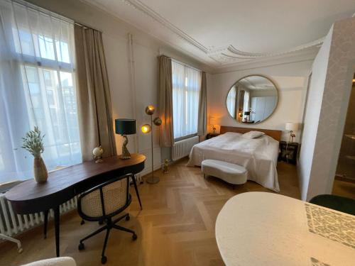 a bedroom with a bed and a desk and a mirror at Exclusive one room apartment next to Zürich main station in Zürich