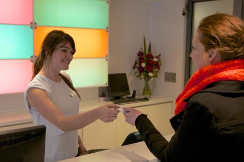 a woman talking to a man in an office at Zero Davey Boutique Apartment Hotel in Hobart