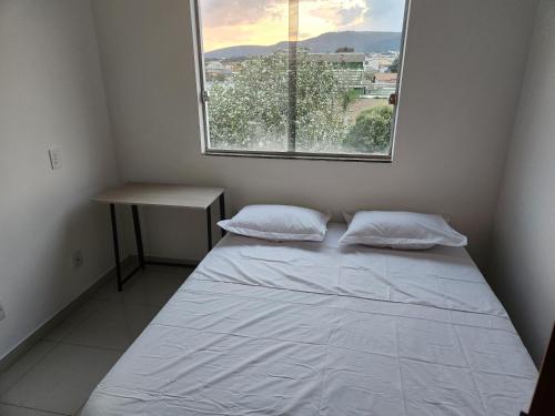 a small bedroom with a bed and a window at Comfort 302 - 4 Quartos no Centro in Sete Lagoas