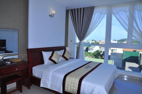 Cam Thanh Hotel في كوانج نجاي: غرفة نوم بسرير ونافذة كبيرة