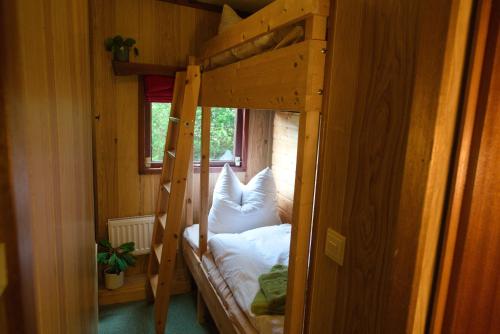a bedroom with a bunk bed with white pillows at Kammbaude Neuhermsdorf in Neuhermsdorf