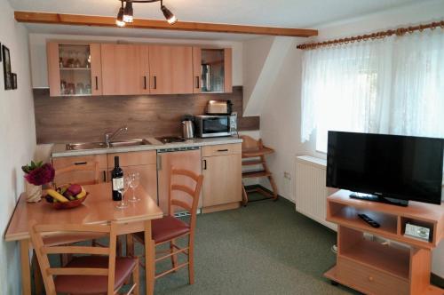 a small kitchen with a table and a television at Kammbaude Neuhermsdorf in Neuhermsdorf