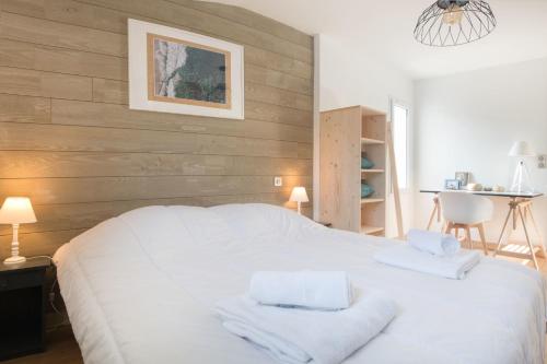 a bedroom with a white bed with two towels on it at DUNE, villa avec piscine et spa / Proche plage in La Couarde-sur-Mer