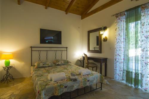 a bedroom with a bed with a television and a desk at Su La Strata Villa by CorfuEscapes in Gaios