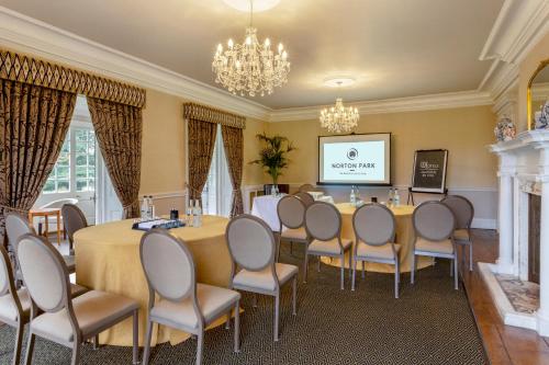 a conference room with a table and chairs and a screen at Norton Park Hotel, Spa & Manor House - Winchester in Winchester