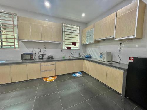eine Küche mit Holzschränken und einem schwarzen Kühlschrank in der Unterkunft Home36#8pax#4bedroom#NearAeonAlma#Mcd in Bukit Mertajam